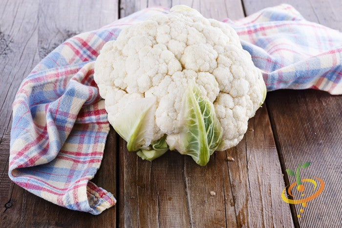 Fresh white snowball cauliflower on checkered cloth on wooden surface representing cauliflower seeds